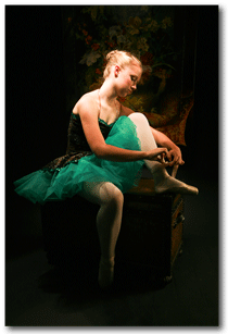 Young Ballet Dancer in beautiful light putting on point shoes.