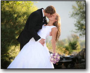 Wedding Photography of groom dipping the bride as he kisses her, outside in beautiful light.