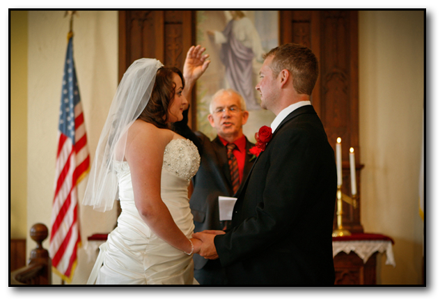 Couple standing at the alter as minster holds ring up blessing it during a Montana Wedding ceremony.